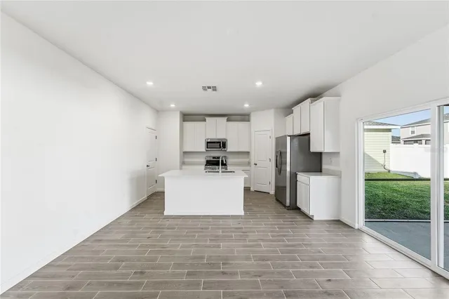 a view of kitchen with stainless steel appliances a refrigerator and a stove top oven