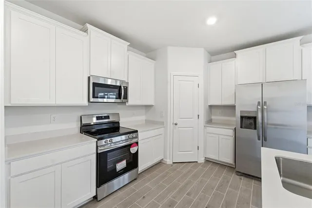 a kitchen with cabinets and steel appliances