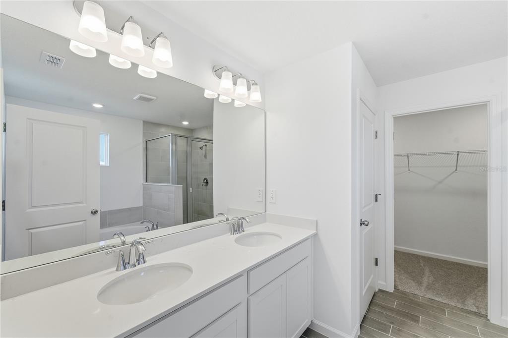 6680 Southwest 89th Loop Ocala, FL 34476 - Photo 24 of 39 a bathroom with double vanity sinks a toilet a shower a vanity and a mirror