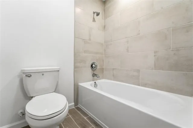 a white toilet sitting next to a bathtub