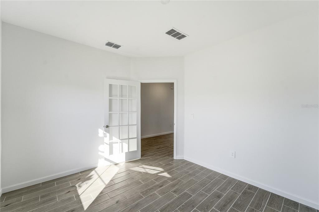 6680 Southwest 89th Loop Ocala, FL 34476 - Photo 38 of 39 a view of an empty room with wooden floor and a window