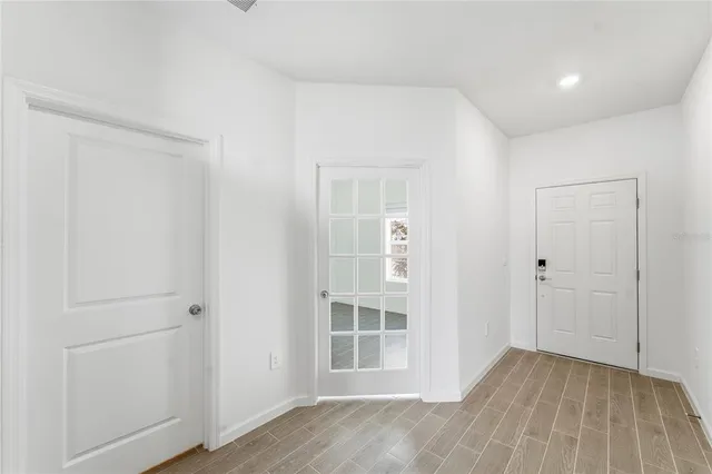 a view of empty room with wooden floor and entryway