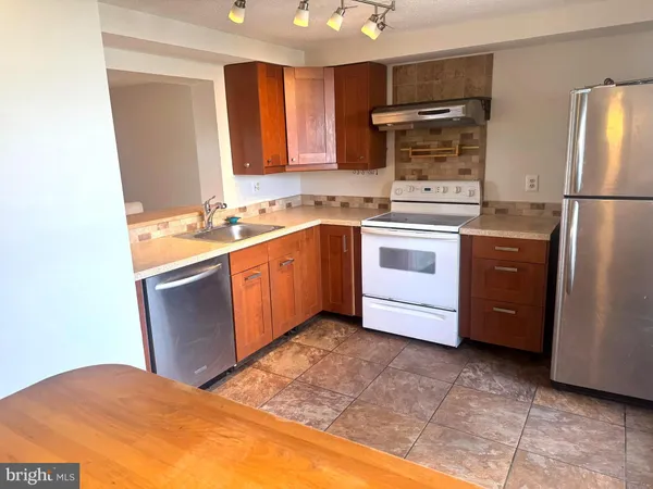 a kitchen with stainless steel appliances granite countertop a stove a sink dishwasher a refrigerator and a microwave