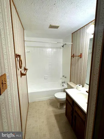a bathroom with a sink a toilet a tub and shower