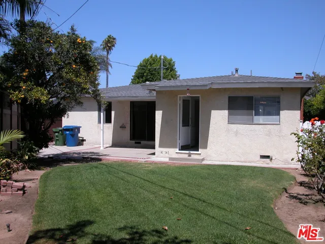 a front view of a house with a garden and plants