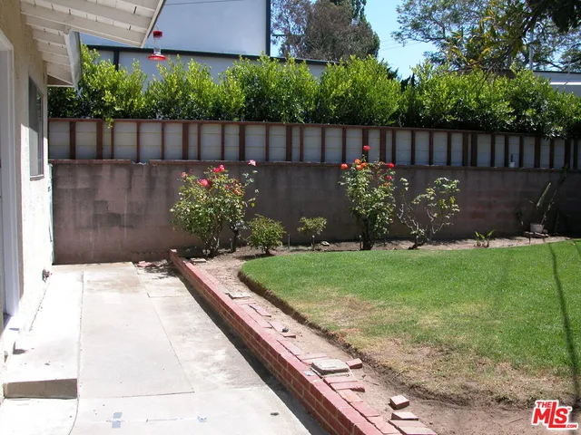 a view of a backyard with wooden fence