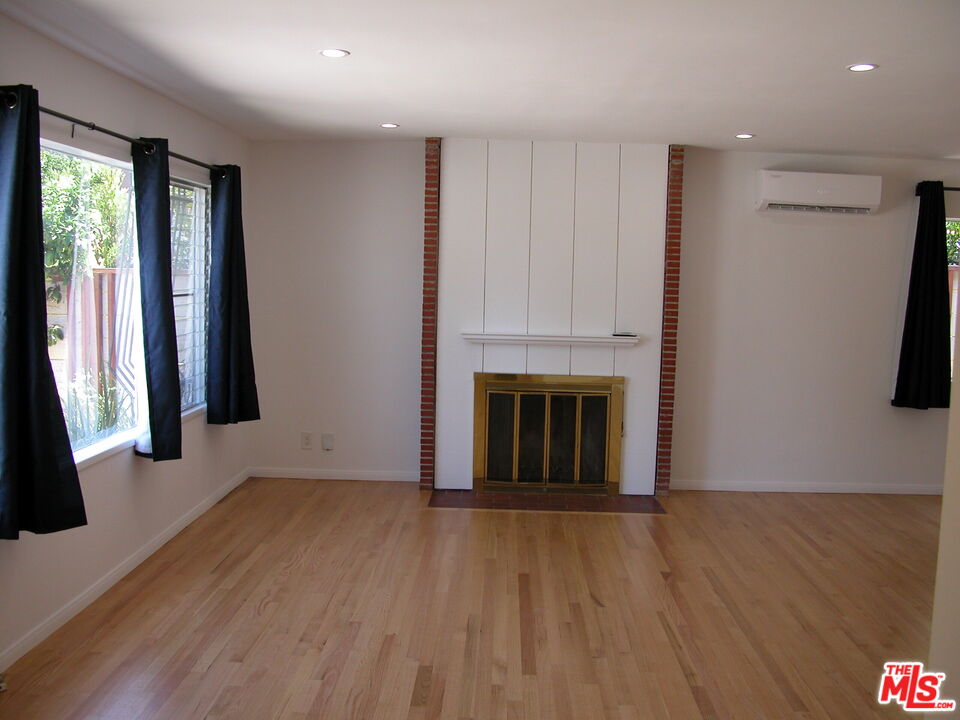 6446 Riggs Place Los Angeles, CA 90045 - Photo 5 of 22 an empty room with wooden floor and a fireplace