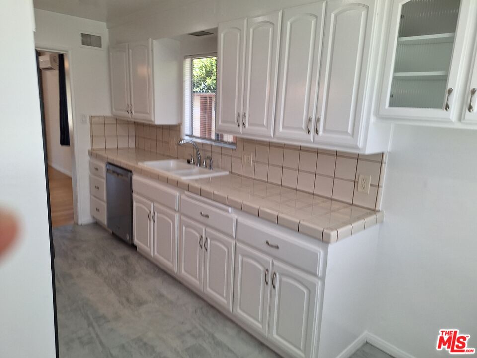 6446 Riggs Place Los Angeles, CA 90045 - Photo 10 of 22 a kitchen with granite countertop white cabinets and sink
