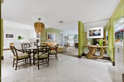 a view of a dining room and livingroom with furniture a rug a painting and a potted plant