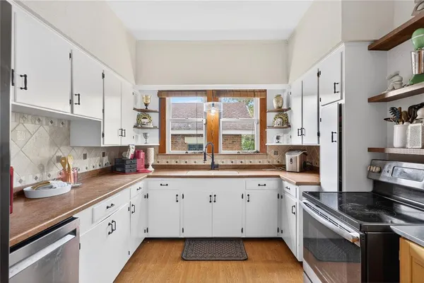 a kitchen with granite countertop a sink stainless steel appliances and cabinets