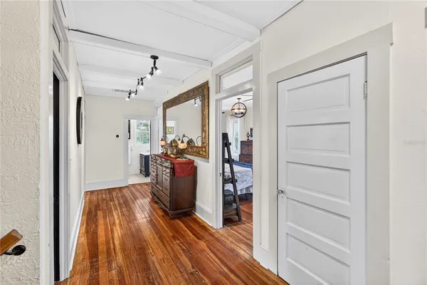 a view of a hallway with wooden floor and closet