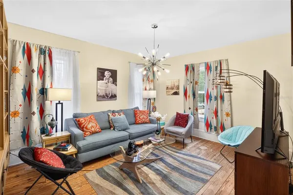 a living room with furniture a flat screen tv and a large window