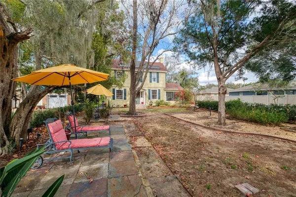 a backyard of a house with table and chairs