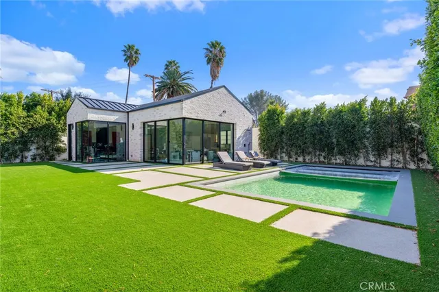 a view of a house with swimming pool and a yard