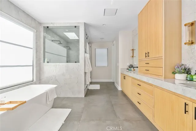 a spacious bathroom with a tub sink shower and mirror