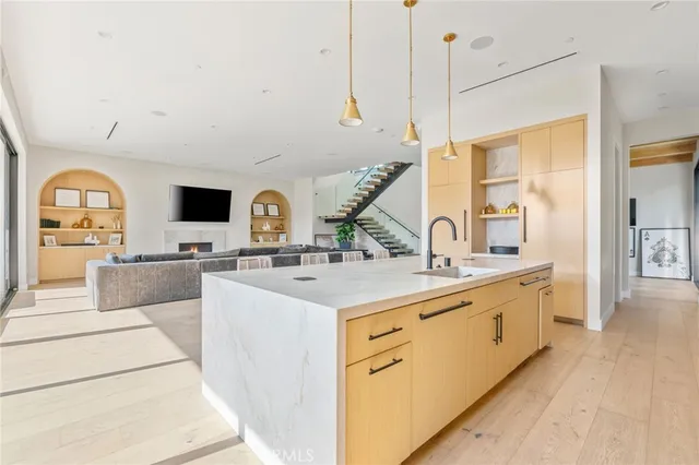 a large kitchen with stainless steel appliances a sink and cabinets