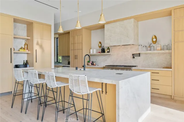 a kitchen with stainless steel appliances granite countertop a table chairs sink and cabinets