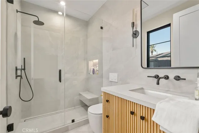 a bathroom with a granite countertop sink a toilet and shower