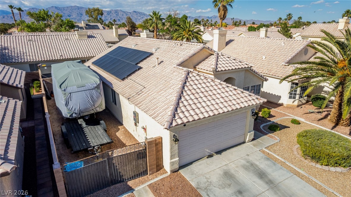 5112 West Camino Del Rancho Las Vegas, NV 89130 - Photo 41 of 44 This residence features solar panels, a tiled roof, and a convenient attached garage, perfect for modern living.