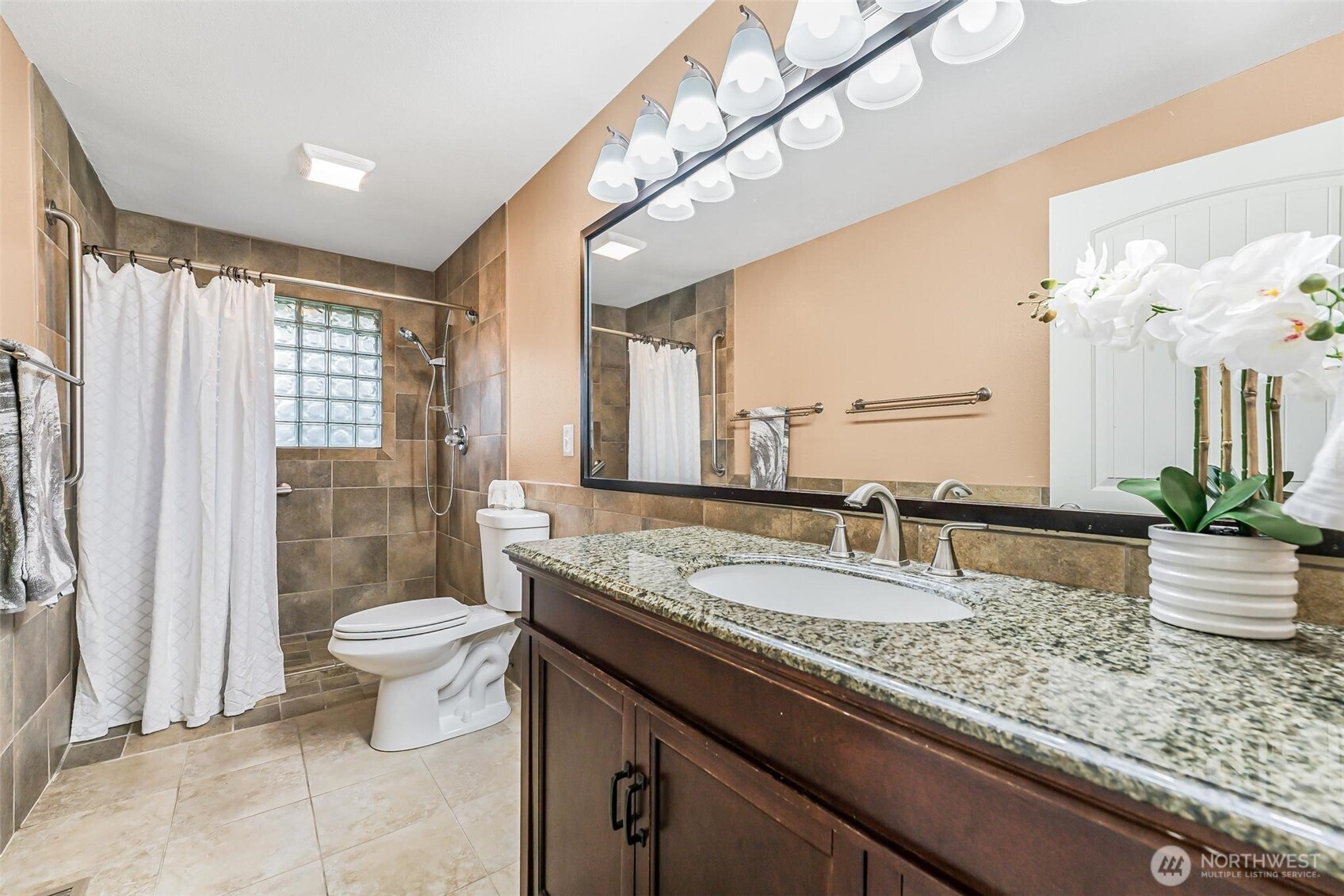 11404 Karshner Road East Edgewood, WA 98372 - Photo 17 of 40 a bathroom with a granite countertop sink a toilet a mirror and bathtub