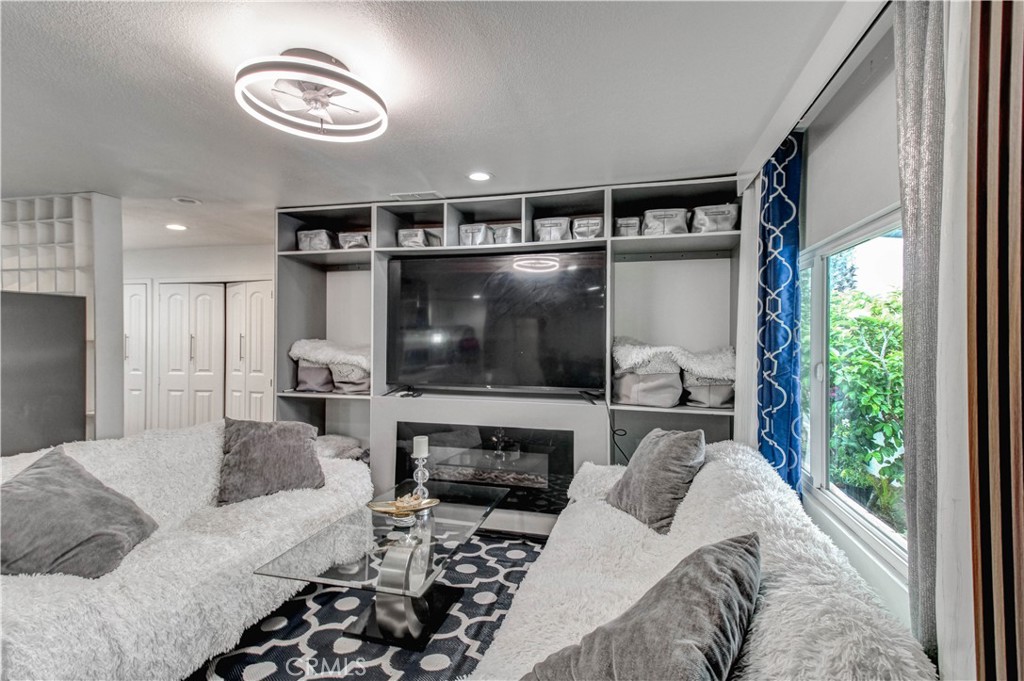 1025 South Riverside Avenue, Unit 26 Rialto, CA 92376 - Photo 9 of 27 a living room with furniture a flat screen tv and a fireplace
