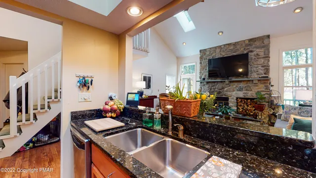 a kitchen filled a sink a counter top space and living room area