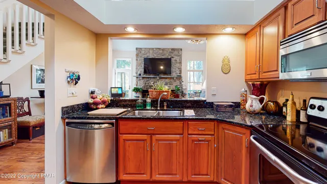 a kitchen with stainless steel appliances granite countertop a sink stove and cabinets