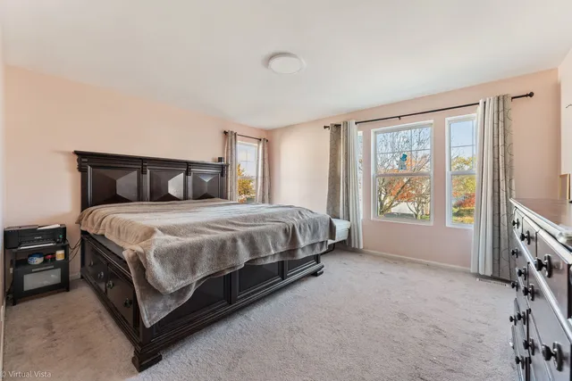 a bed sitting in a spacious bedroom next to a window