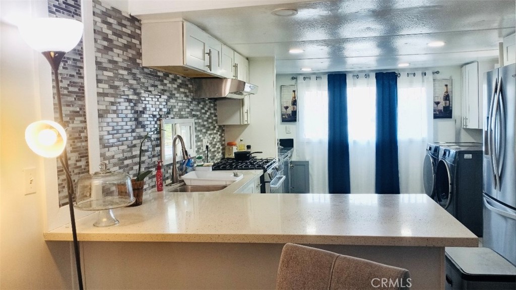 26250 9th Street, Unit 131 Highland, CA 92346 - Photo 1 of 15 a view of a kitchen with kitchen island a sink stainless steel appliances and cabinets