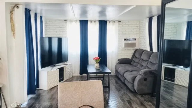 a living room with furniture wooden floor and a flat screen tv
