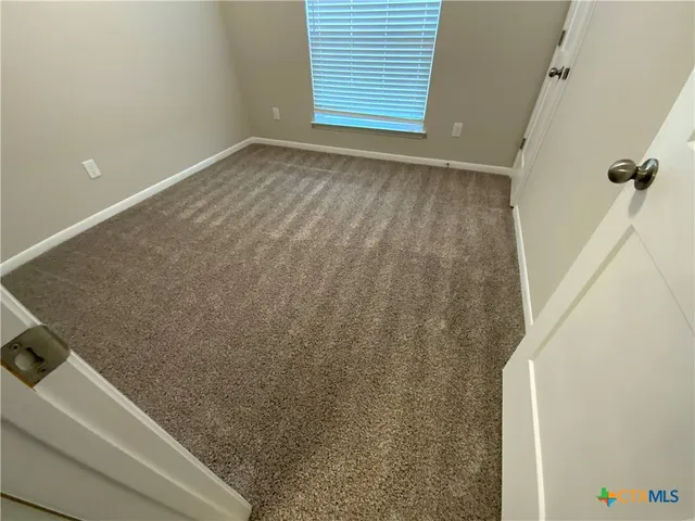 a view of a room with wooden floor and a window