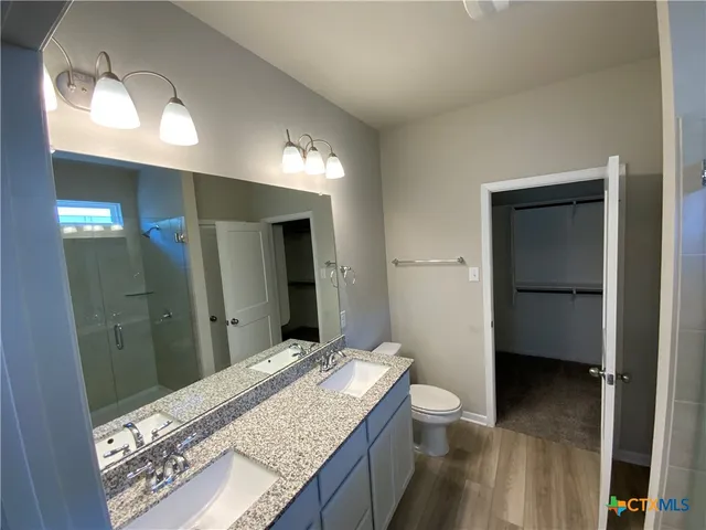 a bathroom with a glass door shower and a sink