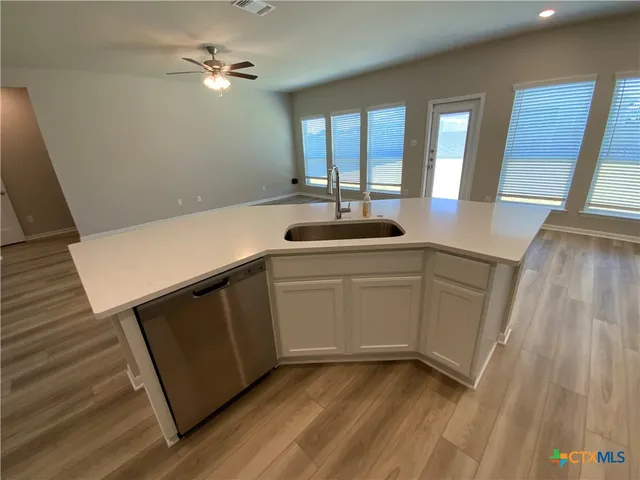 a kitchen with a sink appliances and cabinets