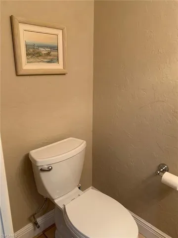 a white toilet sitting next to a white walls