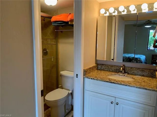 a bathroom with a granite countertop sink toilet and shower
