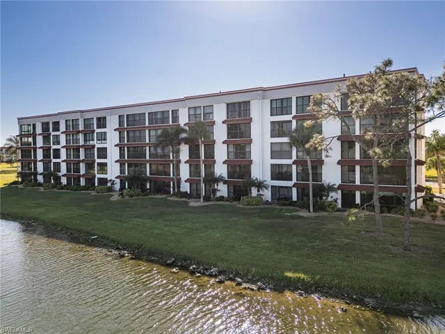 a view of a big building with a big yard and large trees