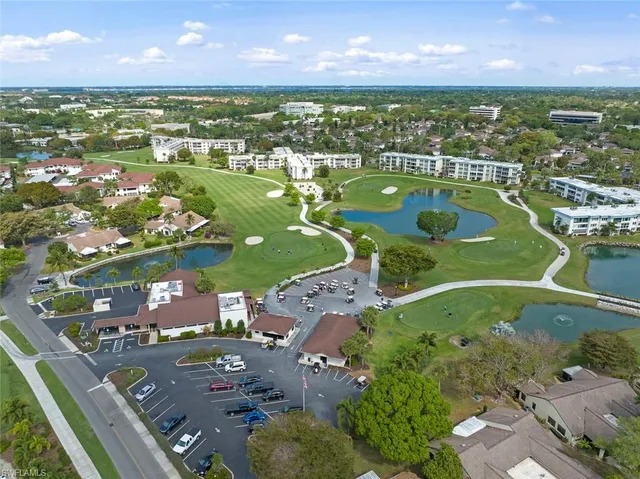 an aerial view of residential houses with outdoor space and a lake view