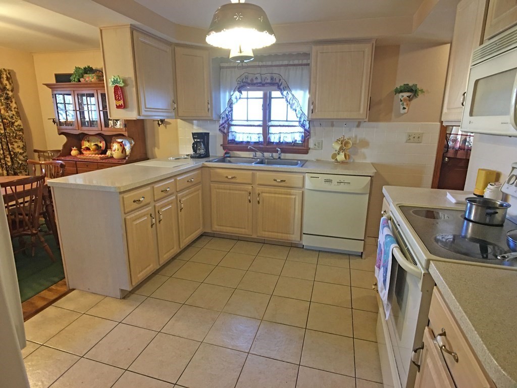 71 Kennedy Street Fall River, MA 02721 - Photo 8 of 28 a kitchen with a sink a stove cabinets and a counter top space