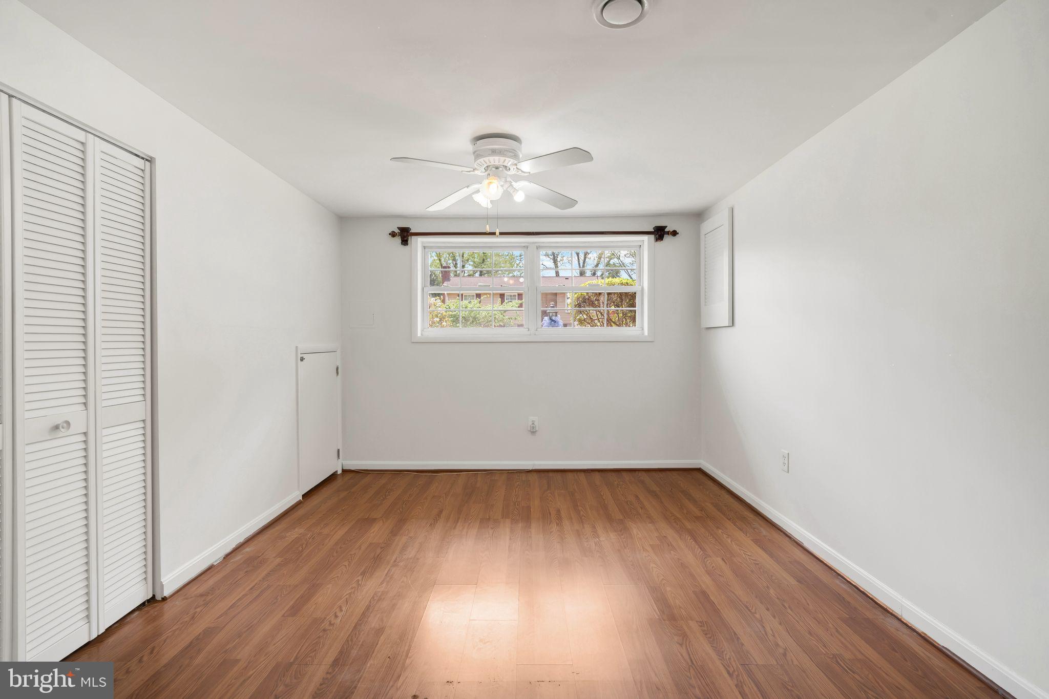 4552 Kinmount Road Lanham, MD 20706 - Photo 36 of 55 an empty room with wooden floor chandelier and windows