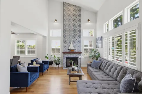 a living room with furniture a fireplace and large windows
