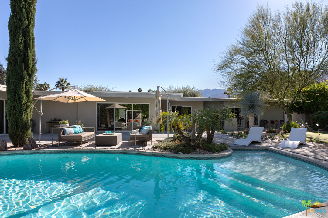 a view of a house with backyard and sitting area