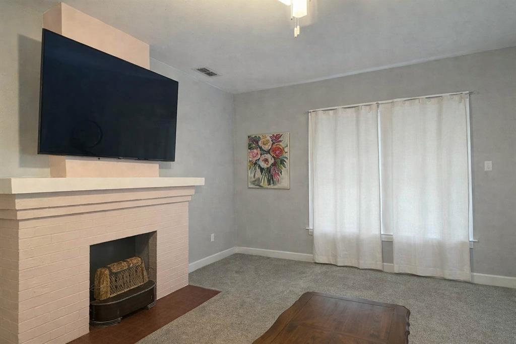 2912 10th Street Wichita Falls, TX 76309 - Photo 6 of 16 a living room with a fireplace and a flat screen tv