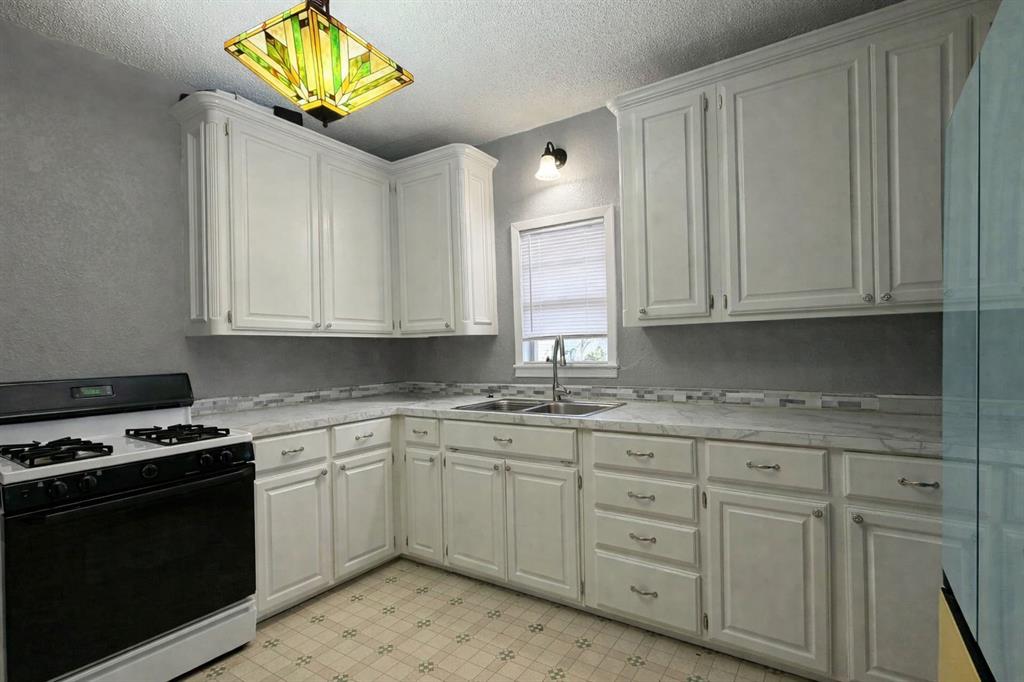2912 10th Street Wichita Falls, TX 76309 - Photo 8 of 16 a kitchen with stainless steel appliances granite countertop a sink a stove a microwave and cabinets