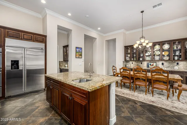 a view of a patio with table and chairs potted plants and floor to ceiling window