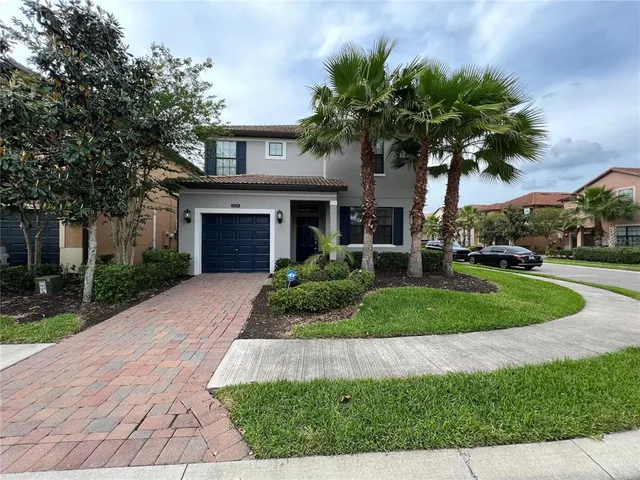 a front view of a house with a garden and palm tree