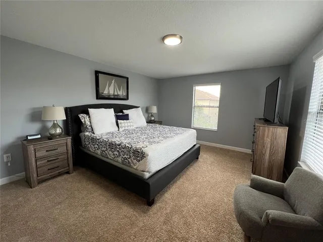 a bedroom with a bed couch and a window