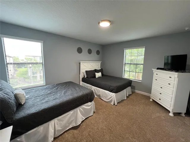 a bedroom with furniture and a flat screen tv