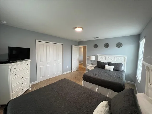 a bedroom with two beds and a flat screen tv