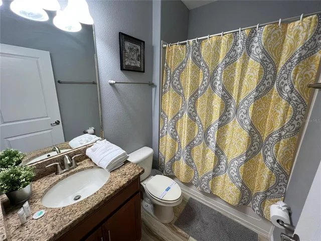 a bathroom with a granite countertop sink toilet and shower