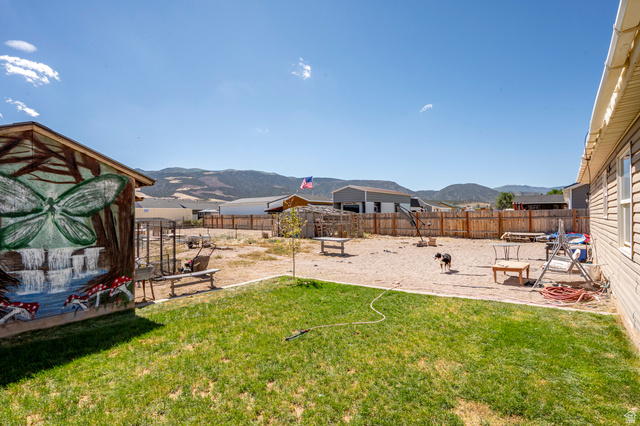4296 Maple Lane Cedar City, UT 84721 - Photo 36 of 44 Expansive backyard featuring a partial grass lawn, a large gravel area, and a wood privacy fence